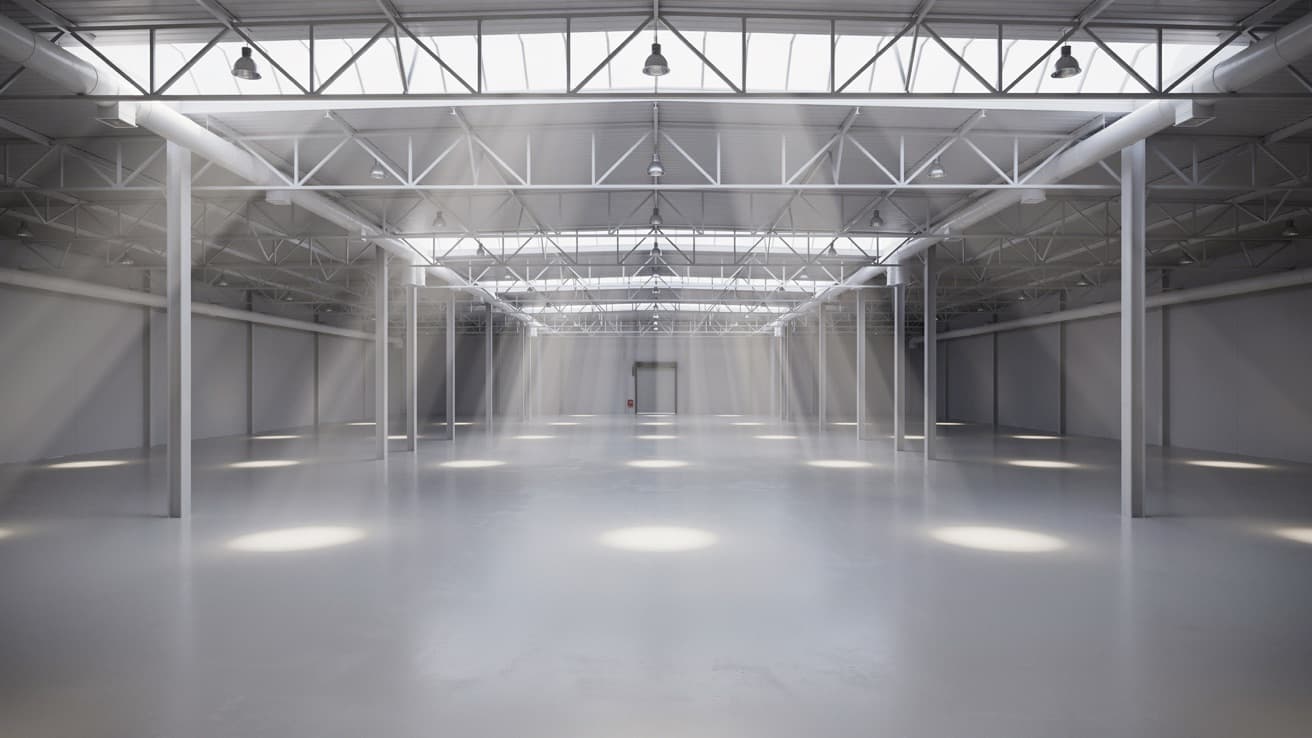 Interior of an industrial building lit by daylight through rooflights and skylights